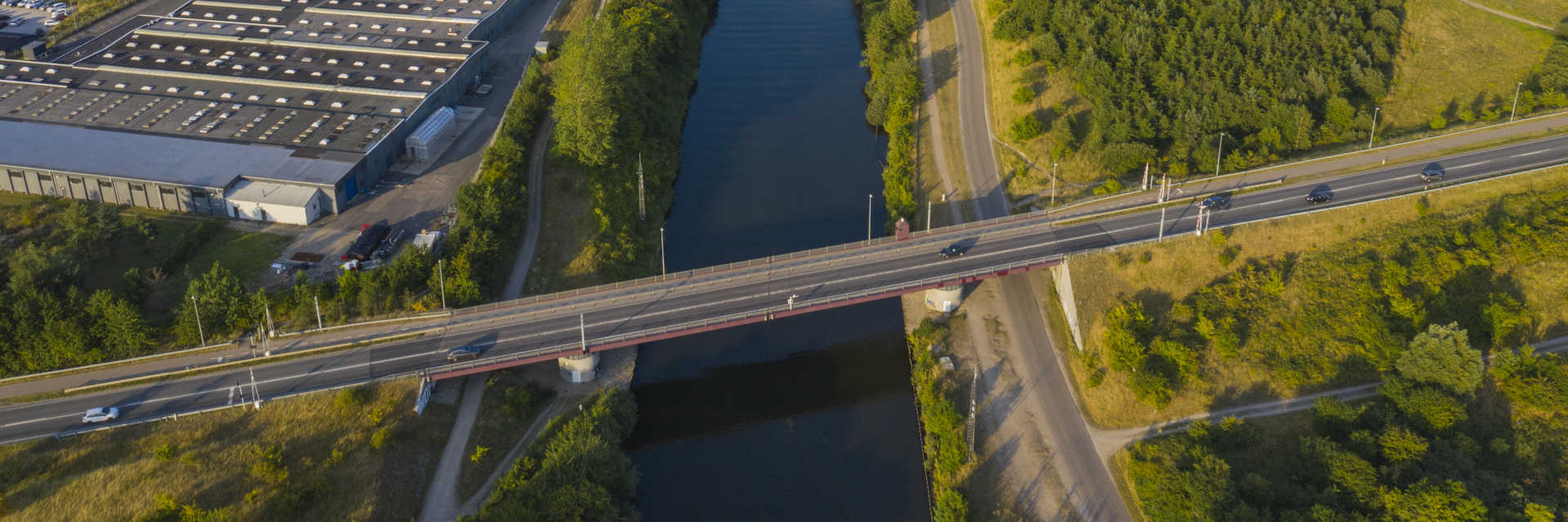 Å løber ind mod by mellem fabrik og markområde